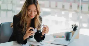 businesswoman finding solution to a jigsaw 